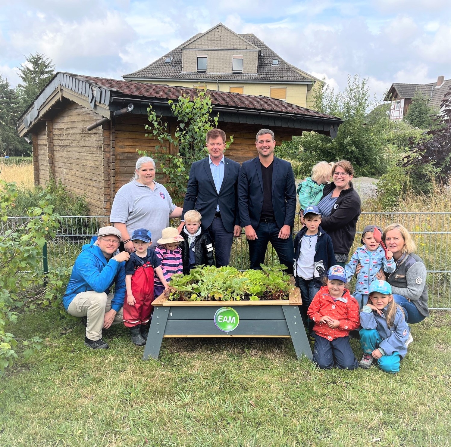 Mehrere Personen um ein Hochbeet stehend