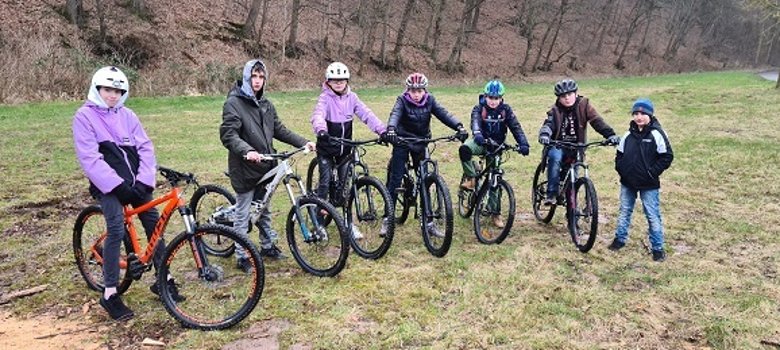 Kinder und jugendliche auf Fahrrädern auf eine Wiese